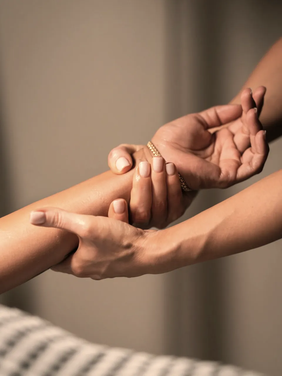 Mãos a massajar o antebraço de uma cliente